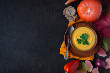 Pumpkin soup on a black stone background. Space for copying. Top view.