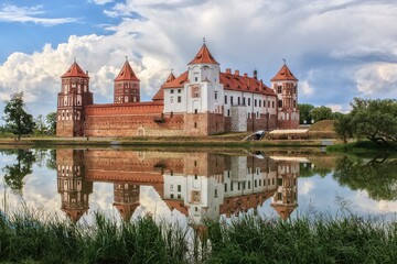 Naklejka na ściany i meble Castle with mirror reflection in the water of lake