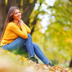 Woman sitting on autumn leaves