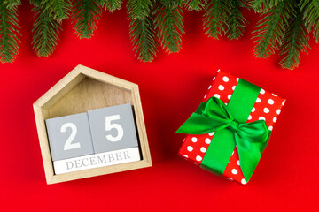 Top view of wooden calendar, gift box and fir tree on colorful background. The twenty fifth of December. Christmas time with copy space