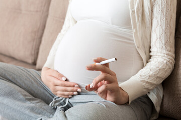Pregnant woman with cigarette at home. mother smoking concept
