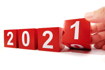 Hand holding wooden cube with flip over block 2020 to 2021