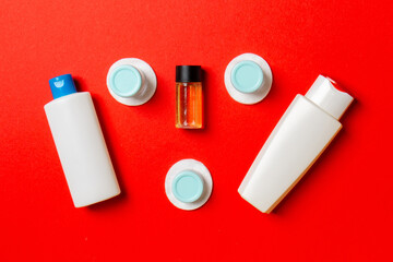 Top view composition of small travelling bottles and jars for cosmetic products on colored background. Facial skin care concept with copy space for your design