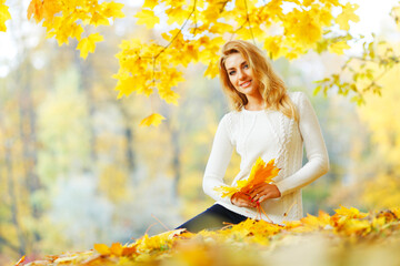 Woman sitting on autumn leaves