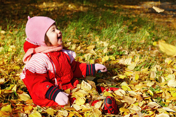 Baby playing with autumn leaves
