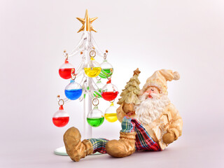 ガラス製のクリスマスツリーと鋳物のサンタクロースのシンプルなイメージ