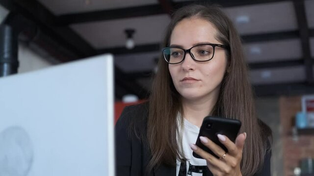 business woman with smartphone working at laptop at home