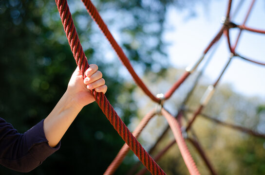 Kinderhand am Seil auf Spielplatz