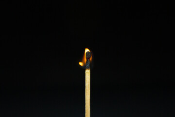 close up Single matchstick burning isolated on black background.