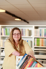 Smiling woman working in library - 383838132