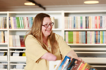 Smiling woman working in library - 383838176