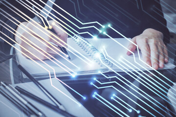 Double exposure of writing hands on background with data solution hologram on front. Technology concept. Close up