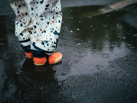 Low section of child standing in puddle