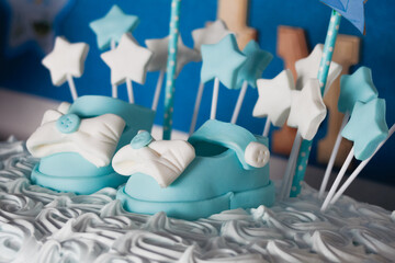 Cream and cream fondant cake with shoes with bows and buttons and stars for party or child...