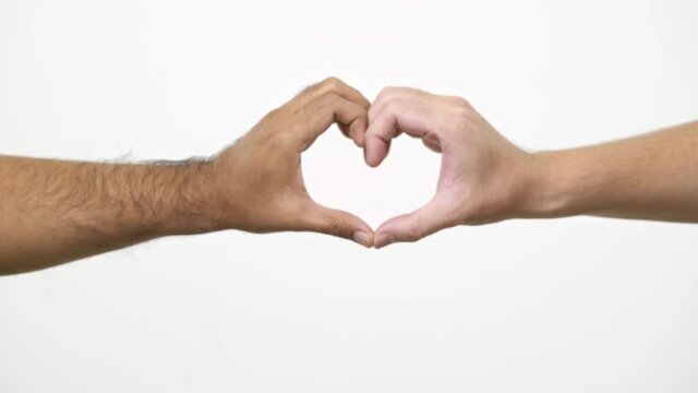 Close up two hands forming heart shape together isolated on the white background. 4K Resolution.