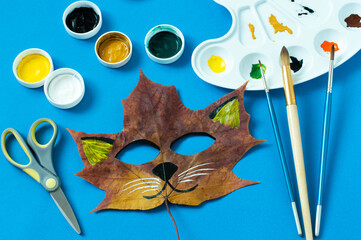 Cat mask painted on maple leaf
