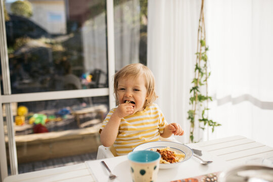 Toddler girl eating at table