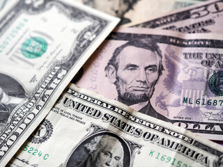 A photo illustration of US various dollar bills ibackground. Selective focus. 1 dollar bill at fioregraund