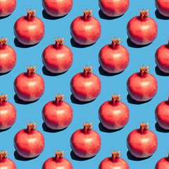 Seamless pattern with pomegranate fruit on blue background.