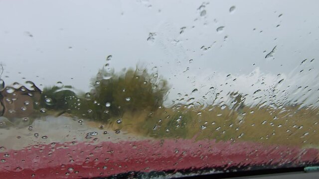 View from inside vehicle as hail sleet and rain hit the windshield  during storm in Wyoming.