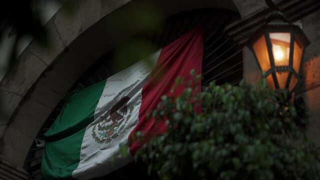 Mexican Flag Hanging Over a Building Arched Entrance