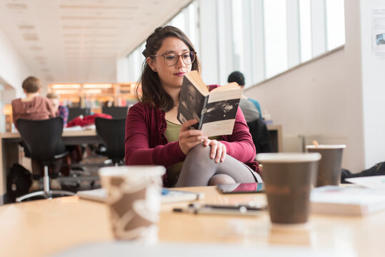 Woman reading book in library
