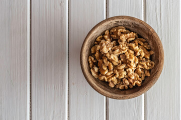 Walnuts in wooden bowl over white background. Top view.