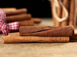 dry brown cinnamon sticks on wooden background