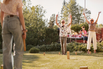 Happy senior couple in garden playing kubb
