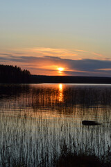 Sunset on the lake. Strong, beautiful colours, clouds and darkening evening. reflection from water and waterplants