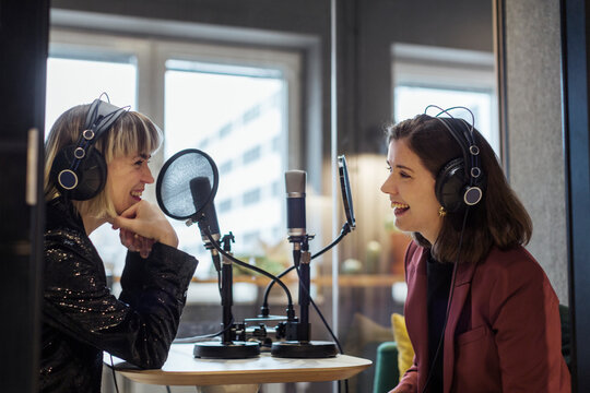 Woman broadcasting podcast from radio station