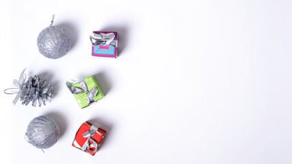 New Year's composition. Christmas gifts, silver balls and pine cone on a white background, flatlay, top view, copy space
