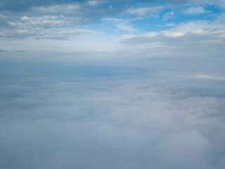 Aerial drone flight over the fog. There are thick clouds of fog below, cloudy.
