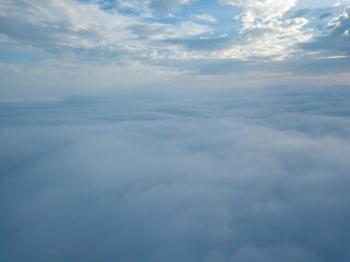 Aerial drone flight over the fog. There are thick clouds of fog below, cloudy.