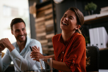 Businessman and businesswoman in office. Two friends drinking coffee while working on the project.