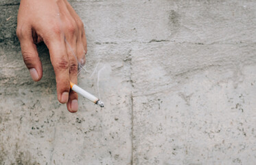 Close up of cigarette in man hand with smoke. man smoking a cigarette.