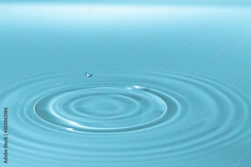 Wall mural drop of water drop to the surface. waves on the surface of the water from a collision