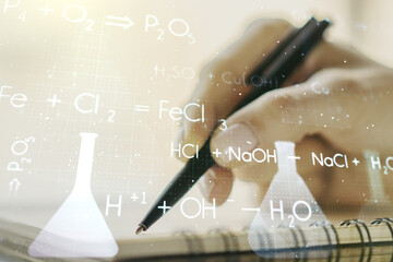 Creative chemistry hologram with man hand writing in notepad on background, pharmaceutical research concept. Multiexposure