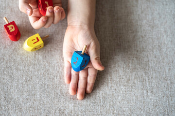Child hand with dreidels for Jewish holiday Hanukkah.