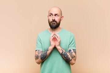 young bald and bearded man scheming and conspiring, thinking devious tricks and cheats, cunning and...