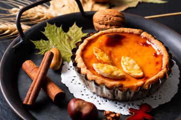 Autumn food concept homemade organic rustic Pumpkins pie decorate by autumn leave on black background with copy space
