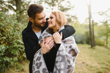 Photo of affectionate bonding couple hug cuddle in autumn september city center park