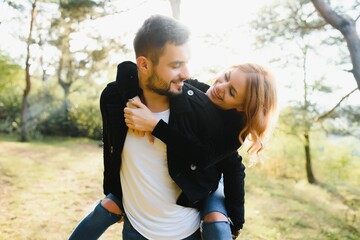 love, relationship, family and people concept - smiling couple having fun in autumn park