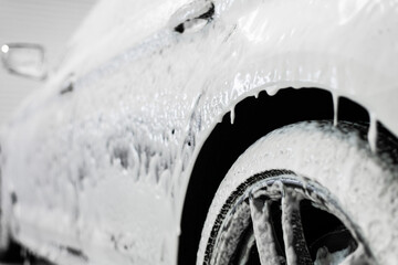 Car washing process. Foaming detergent covers side of the car, clean it from dirt and dust. - 383880543