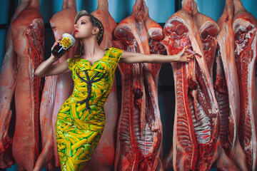 Fototapeta na wymiar Portrait of a blonde woman in a corn cob pattern dress, injecting corn syrup into meat quarters