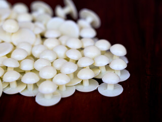 Cream color buttons of cassock against wooden background