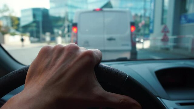 An annoyed driver stands in a traffic jam. The hand rests on the steering wheel, a nervous movement of the finger. Spending time waiting.