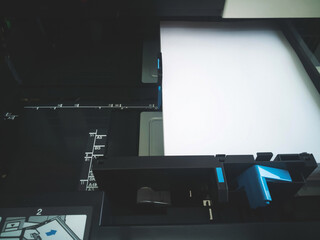 A4 size white paper in tray of laser printer machine in office ready for document printing. Concepts of document printing and scanning technology.