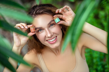 Pretty young woman holding jars with eyeshadows