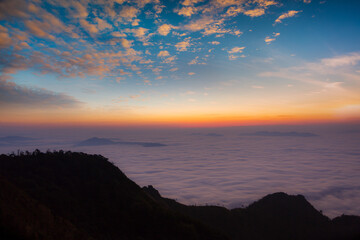 Obraz premium Beautiful landscape nature in morning on peak mountain with sunlight cloud fog and bright blue sky in winter at Phu Chi Fa Forest Park is a famous tourist attraction of Chiang Rai Province, Thailand